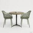 Ronde horecatafel met een tafelblad in Fair Grey kleur, gecombineerd met twee groene designstoelen met open rasterstructuur en een zwart metalen onderstel in een lichte studio-opstelling.