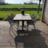 Houten horeca tafel met stalen poot op terras met tuin en bamboe schutting
