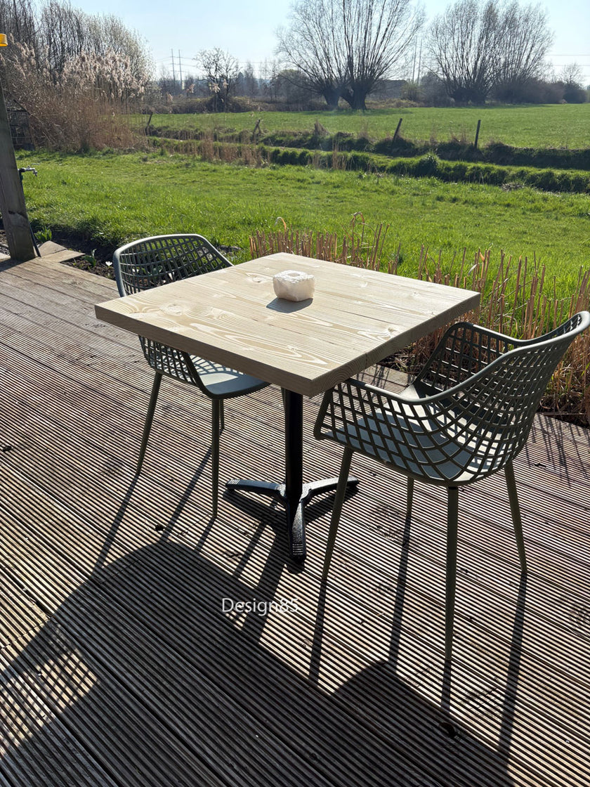 Houten bartafel met zwart metalen onderstel in een sfeervolle achtertuin met gezellige zithoek.