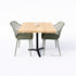 Bartafel met zwart metalen onderstel en blad van onbehandeld douglas hout, gecombineerd met groene kuipstoelen.