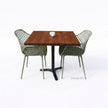 Bartafel met zwart metalen onderstel en warm bruin douglas blad, gecombineerd met groene kuipstoelen.