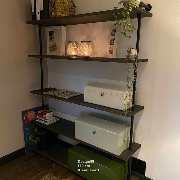 Open industriële vakkenkast met zwarte legplanken, decoratie en planten in modern interieur