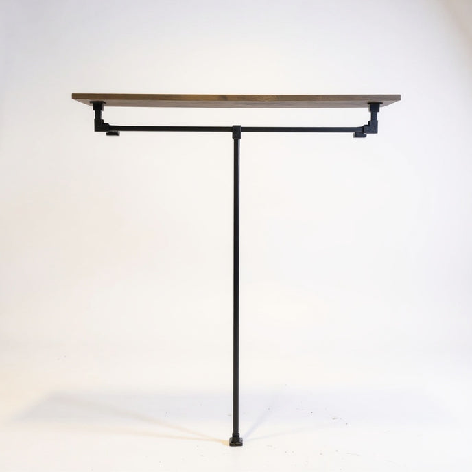 Industriële open kledingkast van zwart staal met legplank in bruin vurenhout op een witte achtergrond.