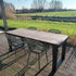 Grote tuintafel van douglas hout met industrieel stalen frame en tuinstoelen