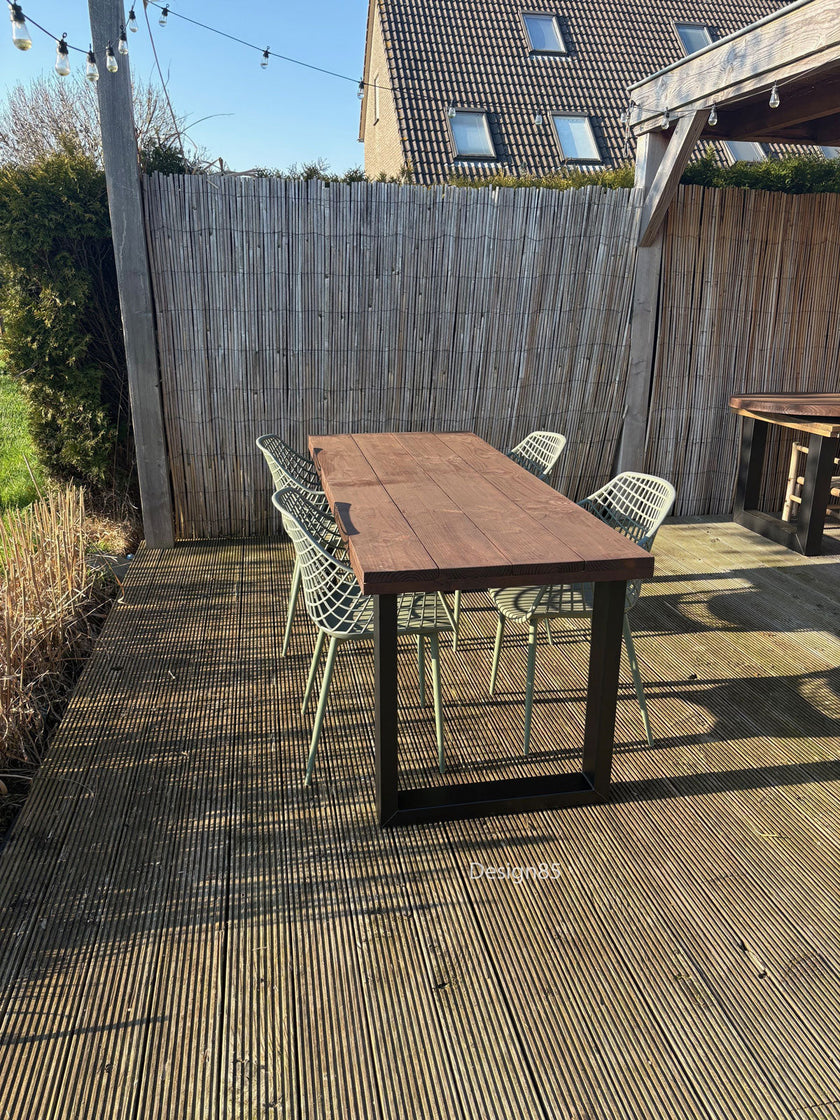 Buiten eettafel van douglas hout met zwart stalen onderstel op houten terras