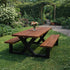 Industriële picknicktafel met houten blad, bijpassende banken en zwart stalen onderstel in een groene tuin.