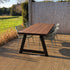 Houten tuintafel met A-frame onderstel en groene stoelen op terras in de achtertuin