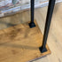 Stoer industrieel kledingrek op wielen van hout en staal voor kleding, jassen en accessoires.