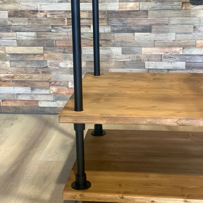 Kledingrek wielen presentatie met houten onderplanken, zwarte buizen en vier zwenkwielen.