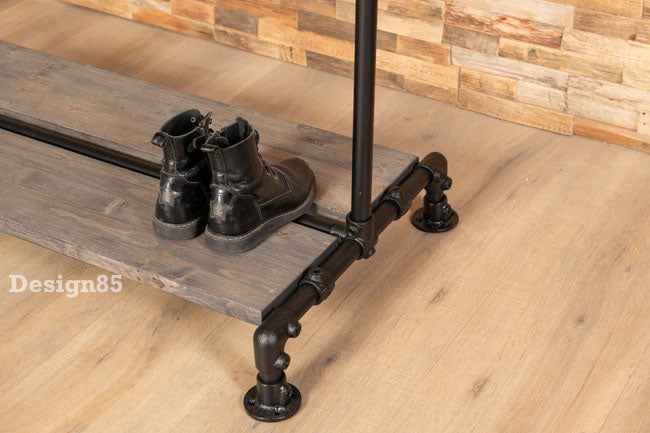 Onderste houten schoenenplank van industrieel kledingrek met zwarte steigerbuizen en schoenen