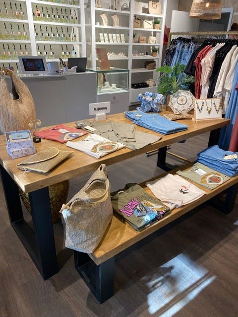 Industriële presentatietafel winkel met twee niveaus voor het stijlvol presenteren van kleding en accessoires.