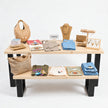 Presentatietafel winkel van onbehandeld vurenhout met zwart stalen onderstel voor kleding en accessoires.