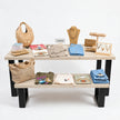 Presentatietafel winkel met wit gebeitste houten bladen en zwart stalen onderstel voor een stijlvolle presentatie van kleding en sieraden.
