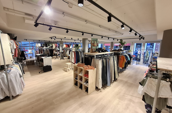 Steigerbuis kledingrekken in een kledingwinkel van Leger des Heils.