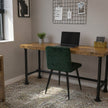 Vintage bureau van massief hout met industrieel zwart stalen onderstel, geplaatst in een moderne werkkamer met groene stoel, laptop en natuurlijke lichtinval