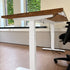 Elektrisch verstelbaar zit sta bureau met een naturel vurenhouten blad, witte stalen poten en een ergonomisch ontwerp voor de werkplek.